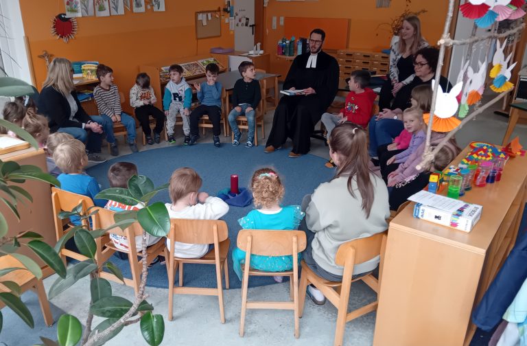 Der evangelische Pfarrer Herr Fischer stellt sich vor und bringt den Kindern eine religiöse Legegeschichte mit