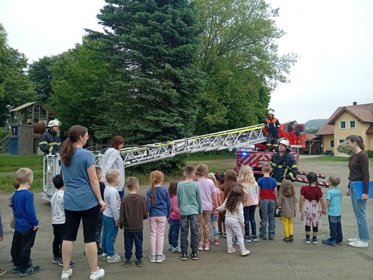 Die Kinder werden vorbereitet auf ihre Fahrt mit der Drehleiter der Feuerwehr.