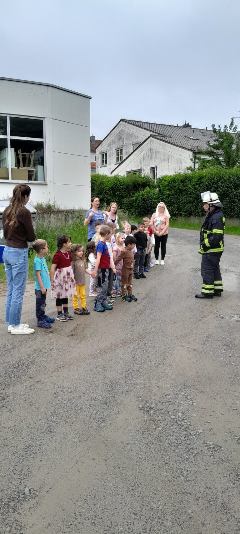 Die Kinder werden vorbereitet auf ihre Fahrt mit der Drehleiter der Feuerwehr.