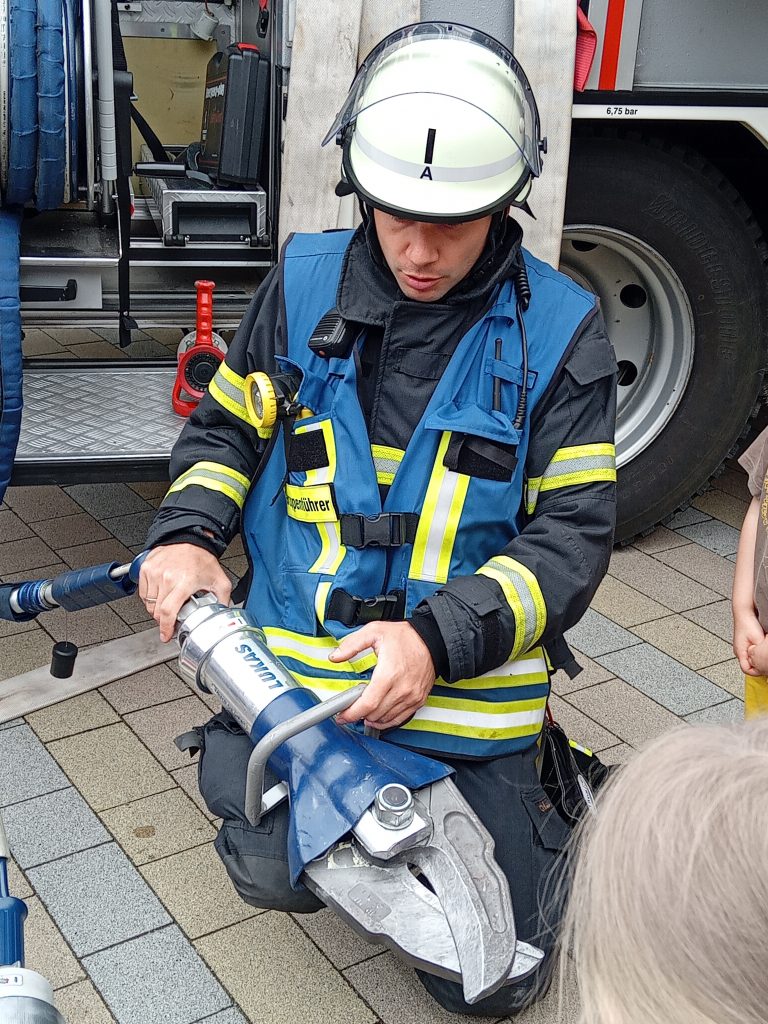 Wir dürfen das Feuerwehrauto erkunden. Die Feuerwehrmänner erklären uns die einzelnen Utensilien im Feuerwehrauto.