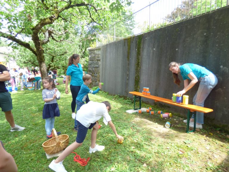Die Kinder haben großen Spaß beim Dosen werfen.
