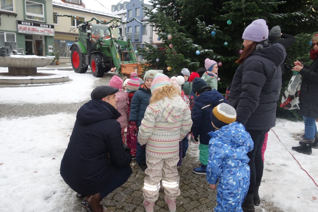 Wir hängen unsere selbst gebastelten Kugeln an den Baum am Marktplatz. Bürgermeister Hr. Teplitzky und einige Stadtmitarbeiter helfen uns dabei.
