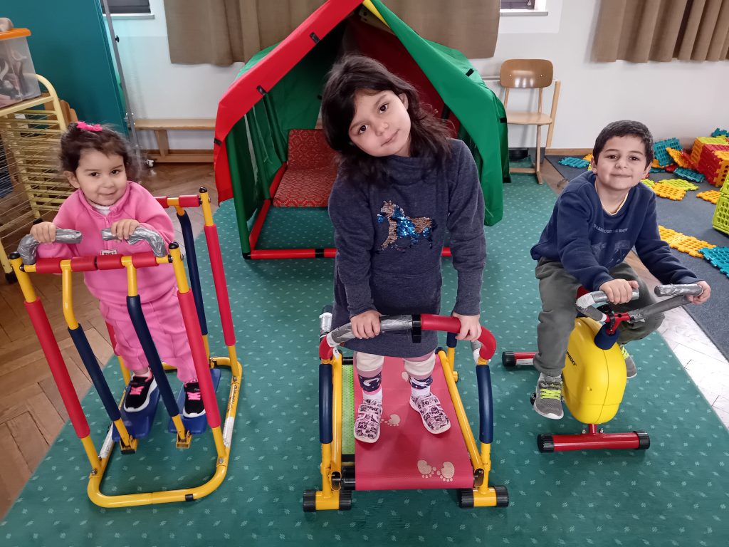 Die Kinder halten sich an den Fitnessgeräten fit.