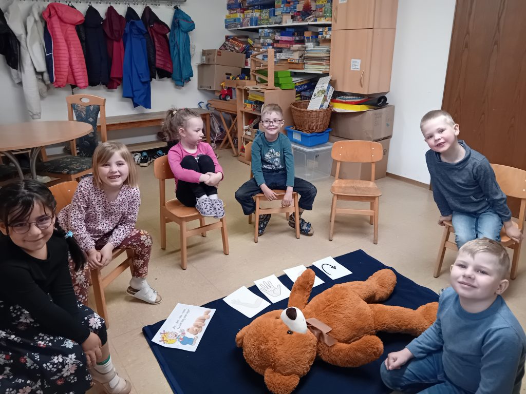 Die Mäusevorschulkinder üben mit einem Teddy die stabile Seitenlage
